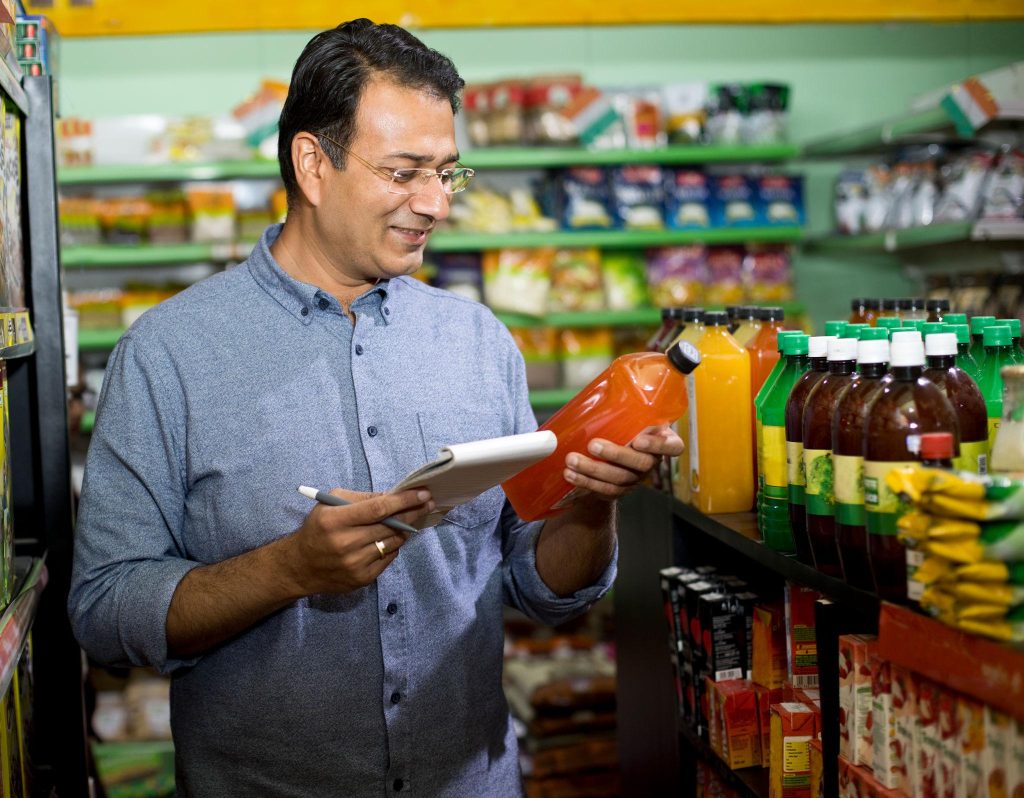 Retail executive with a tablet checking products in a neighbourhood store