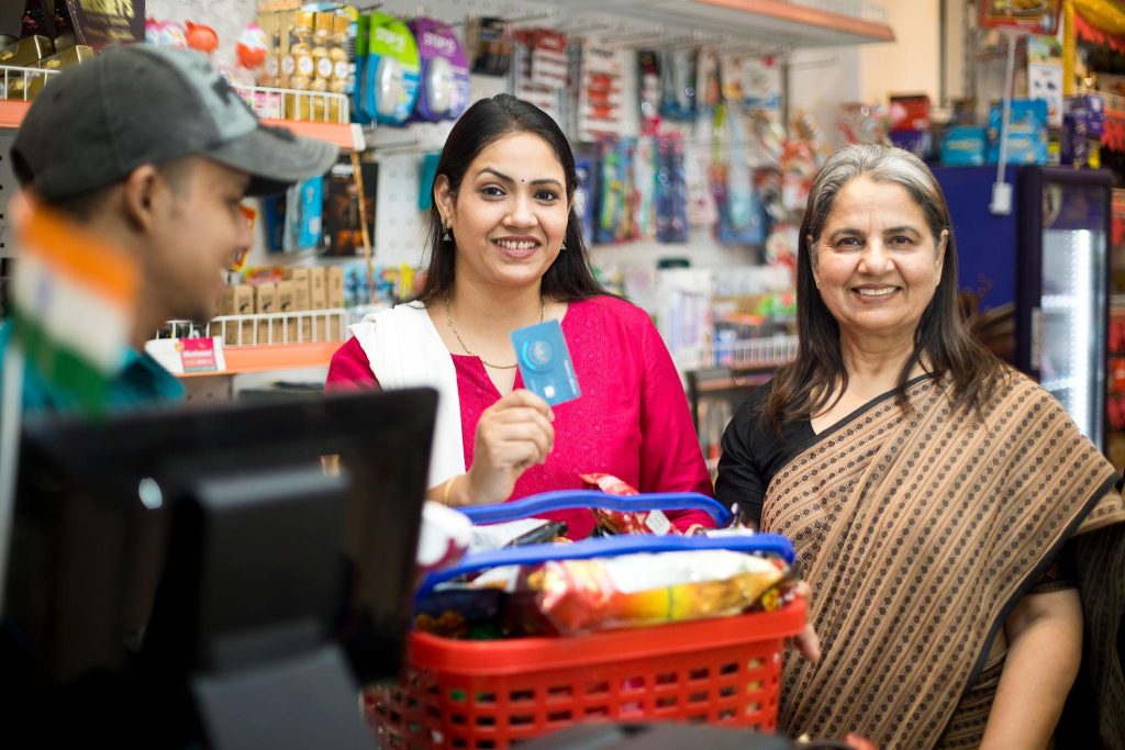 Shoppers at a store billing counter with a basket of products